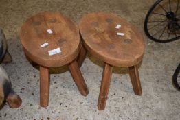 Pair of small oval elm topped milking stools, 31cm wide