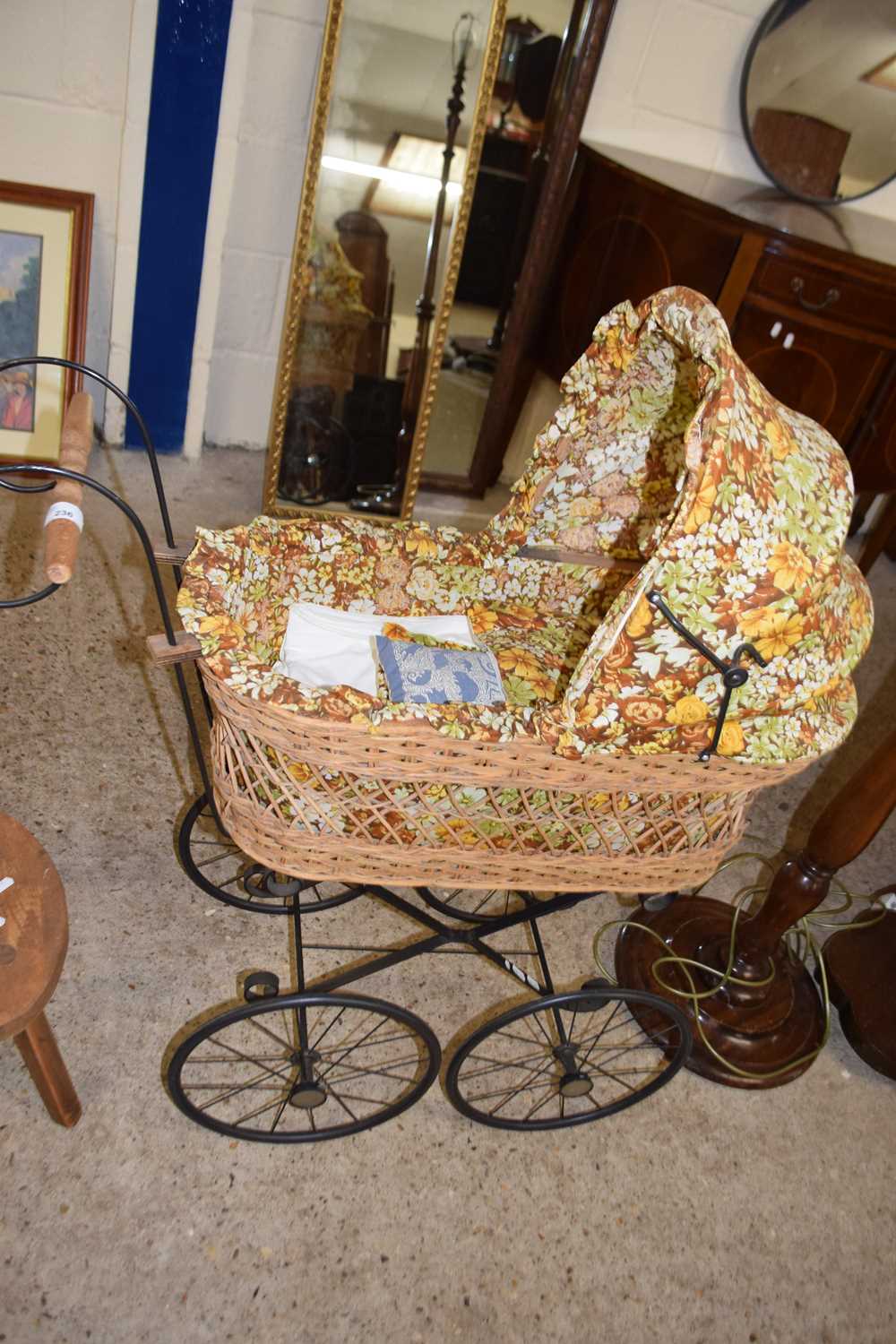A small metal framed pram with floral fabric hood