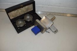 A cased pair of pewter salts together with a cigarette lighter, cigarette rolling machine, tobacco