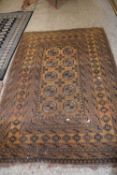 Middle Eastern wool floor rug decorated with central panel of lozenges on a dark amber background
