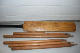 A vintage cricket bat marked Treble Spring Driver together with cricket stumps
