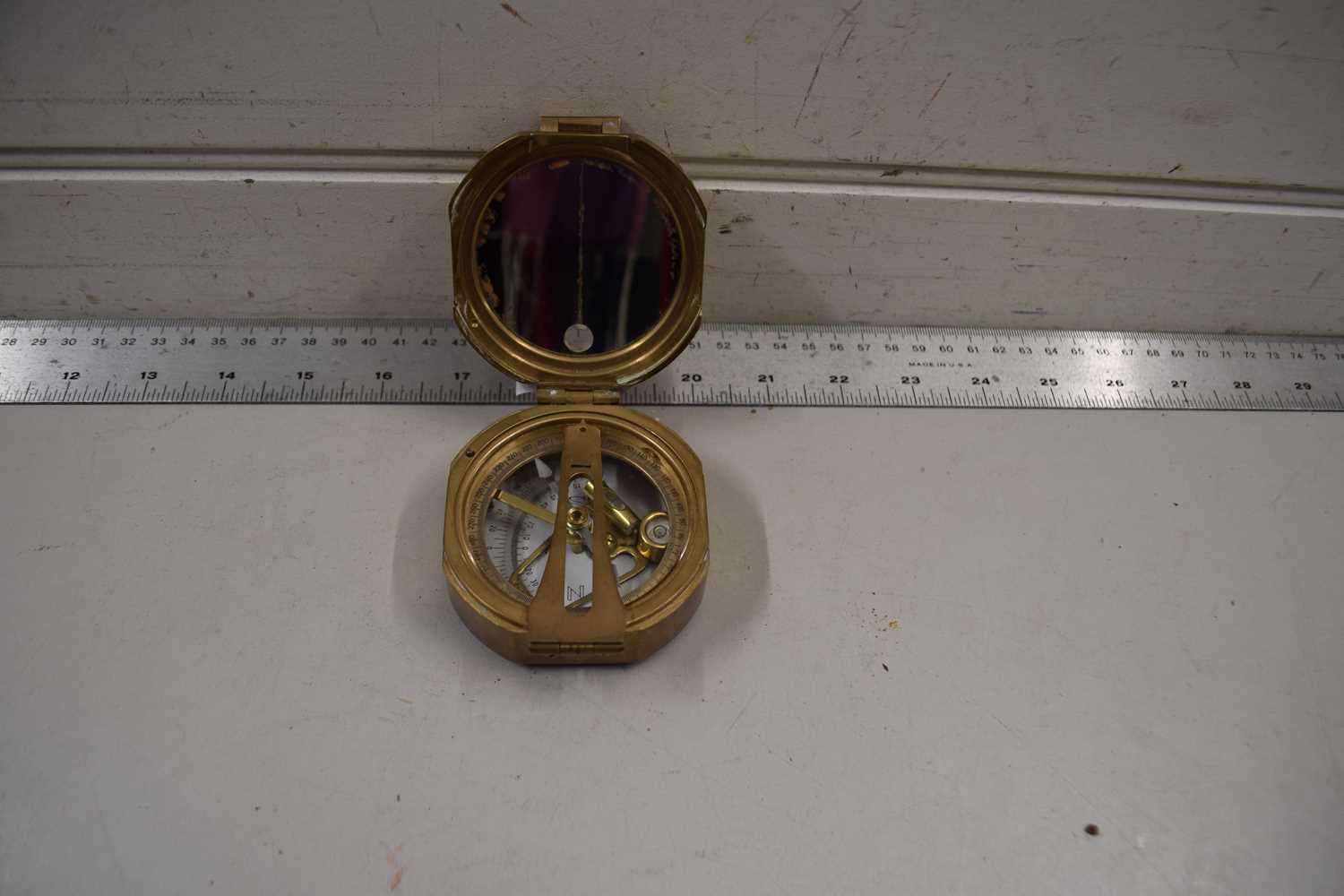 A brass cased compass with hinged lid marked No.777, 7cm wide