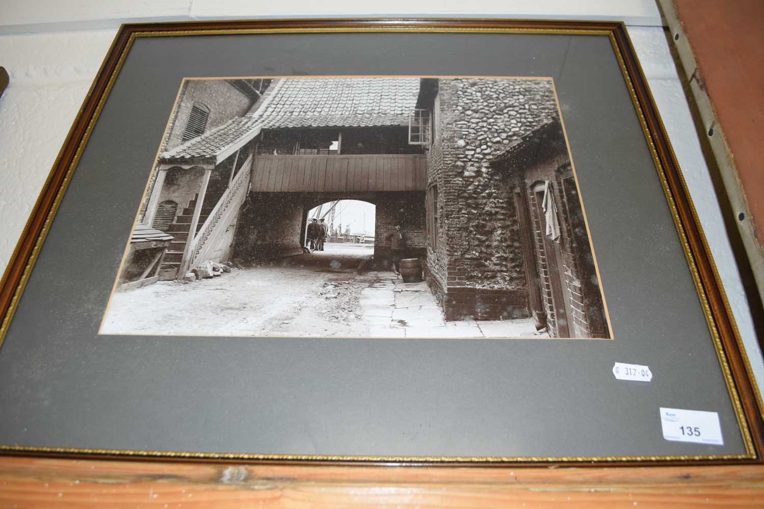 Framed black and white photograph of a port side yard with figures