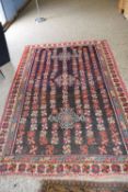 Middle Eastern wool floor rug decorated with large central panel with stylised floral detail on a