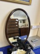 An oval bevelled wall mirror