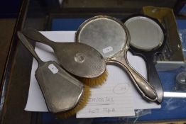 A silver backed mirror and hairbrush together with an ebony mirror and a white metal brush (4)