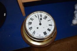 A wooden mounted and brass cased wall clock