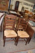 Three rush seated ladder back chairs together with another similar (4)