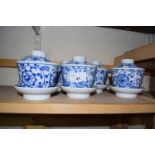 Six modern blue and white tea bowls, saucers and covers