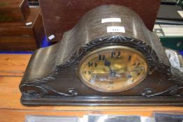 A large wooden mantel clock with brass dial