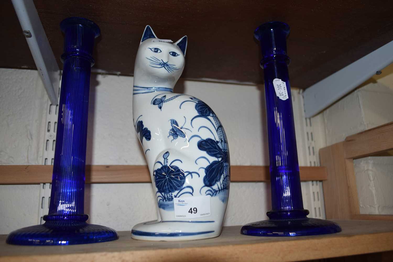 Two blue glass candlesticks and a blue and white pottery cat