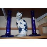 Two blue glass candlesticks and a blue and white pottery cat