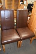 A pair of faux leather dining chairs