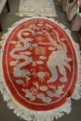 RED GROUND CHINESE RUG WITH DRAGONS AND CHINESE CHARACTERS, APPROX 155CM LONG