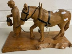 Carved wooden model of a man leading a horse
