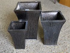 A graduated set of three flared metal square formed planters