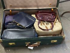 Suitcase containing various vintage handbags