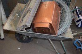 Wheelbarrow containing rolls of wire and various other items