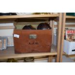 A leather case with four lawn bowls