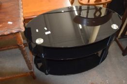 An oval black glass television stand