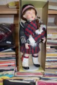 Collectors doll on stand of a Highland Piper in traditional Scottish dress, boxed