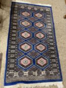 Modern floor rug with geometric design on a blue background, 167 x 94cm