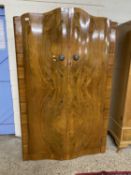 An Art Deco style walnut veneered serpentine front two door wardrobe, 120cm wide