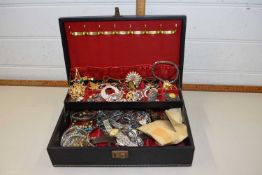 A black jewellery box and a quantity of costume jewellery to include brooches, earrings, white metal