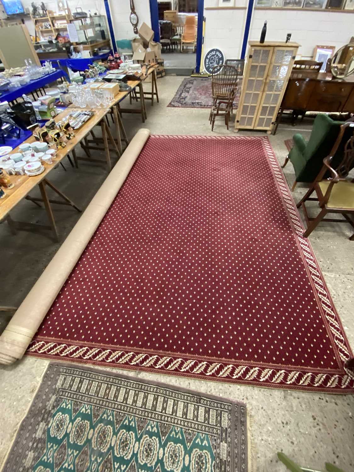 An extremely large modern maroon red floor rug with floral border
