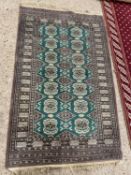 20th Century floor rug decorated with geometric design on a green background, 93 x 145cm