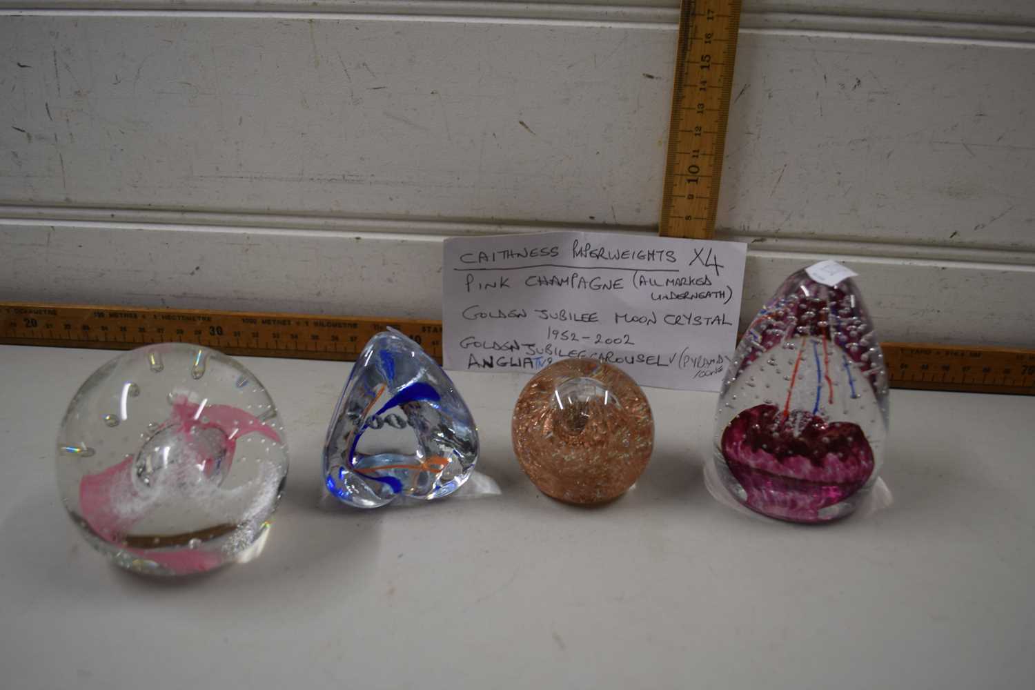 Four Caithness paperweights, Pink Champagne, Golden Jubilee Moon Crystal, Golden Jubilee Carousel