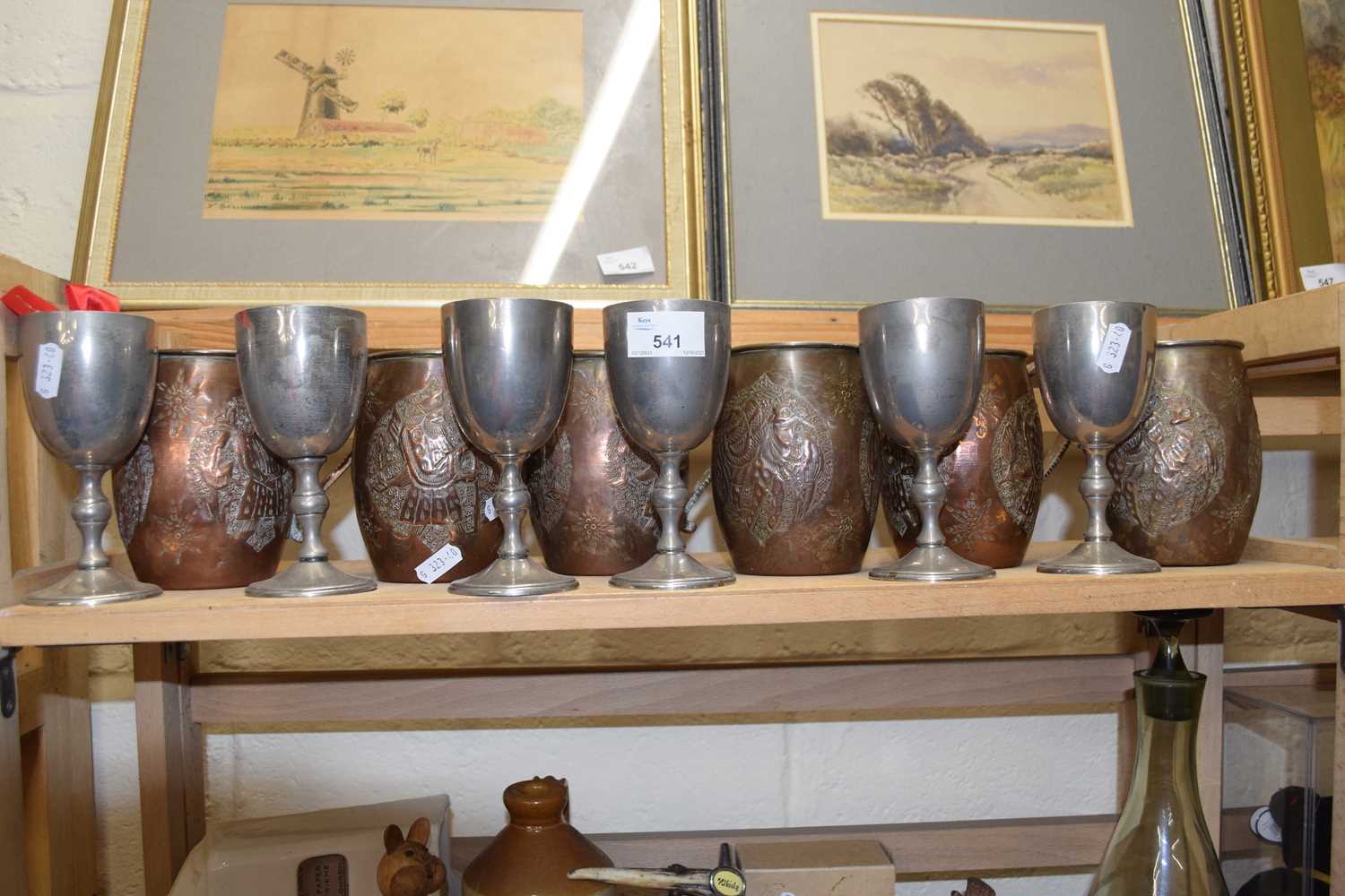Six copper finish barrel shaped and embossed tankards together with six white metal goblets