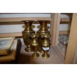 Pair of eastern style decorated metal ware vases together with a pair of plain brass vases