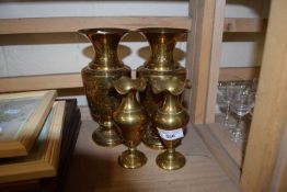 Pair of eastern style decorated metal ware vases together with a pair of plain brass vases