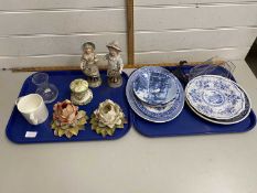 Two trays of mixed wares to include continental figures, rose formed porcelain handle holders,