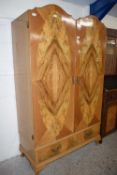 20th Century two door walnut veneered wardrobe with arched doors over a single drawer base, 118cm