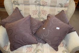 A set of five brown patterned scatter cushions