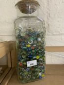 A glass vase and a quantity of marbles
