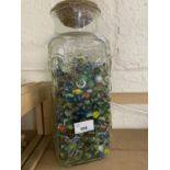 A glass vase and a quantity of marbles