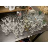 Large quantity of assorted drinking glasses to include liqueur glasses, wine glasses, brandy