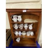 A wooden display rack together with a quantity of Royal Worcester sparrow beak jugs