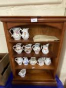 A wooden display rack together with a quantity of Royal Worcester sparrow beak jugs