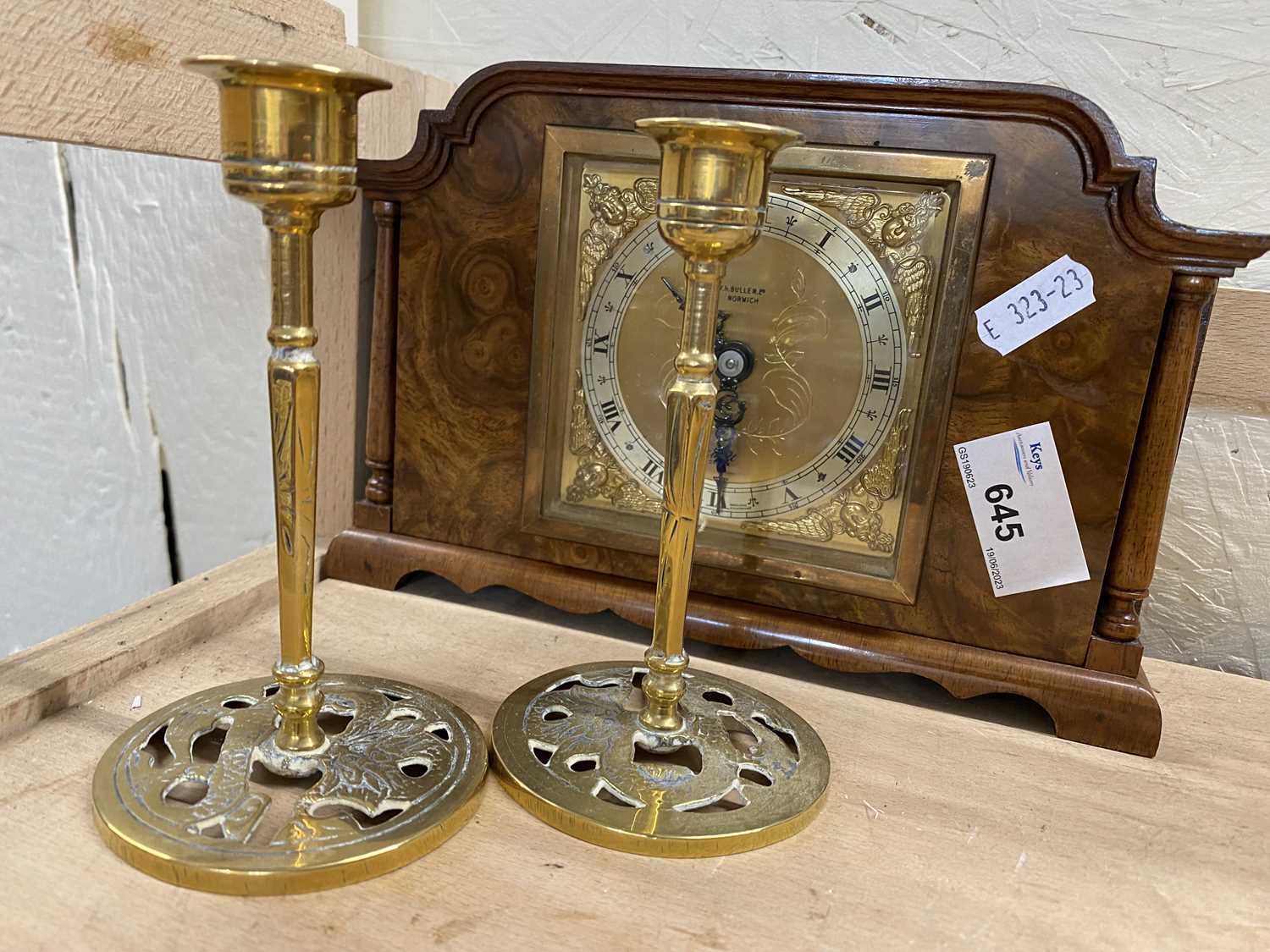 Wooden mantel clock with square brass dial and a pair of dwarf brass candlesticks
