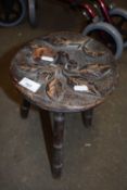 Small three legged stool with carved floral decoration