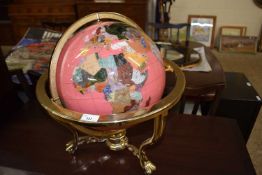 A hard stone inlaid pink globe on brass stand