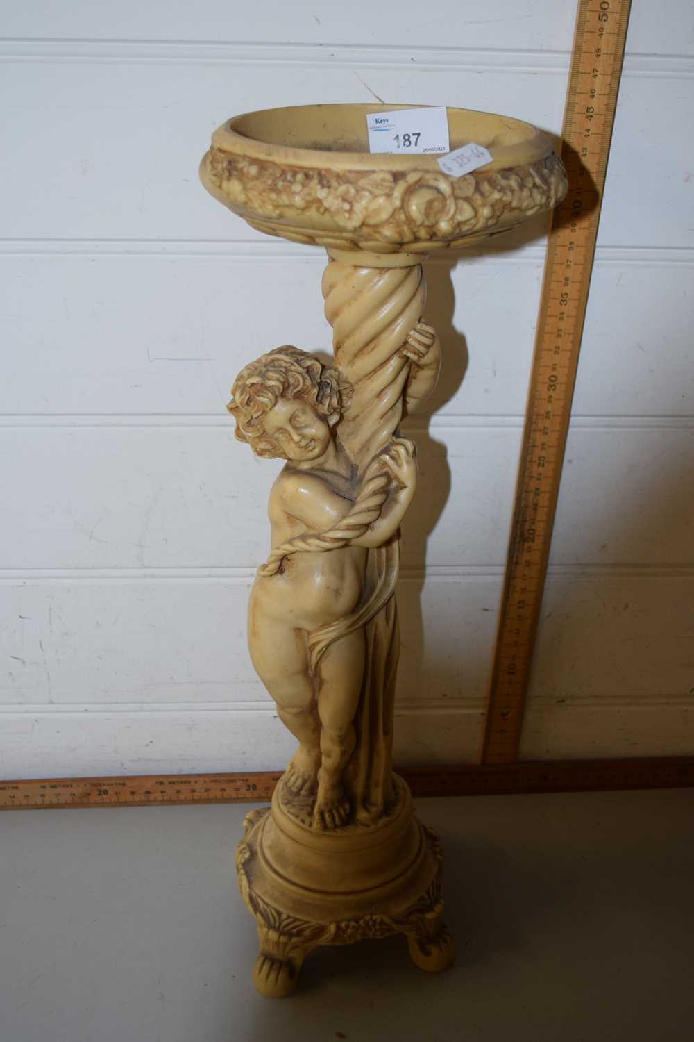 Resin plant stand modelled as a classical cherub on circular base