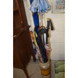 A pottery large vase/umbrella stand together with a quantity of assorted umbrellas