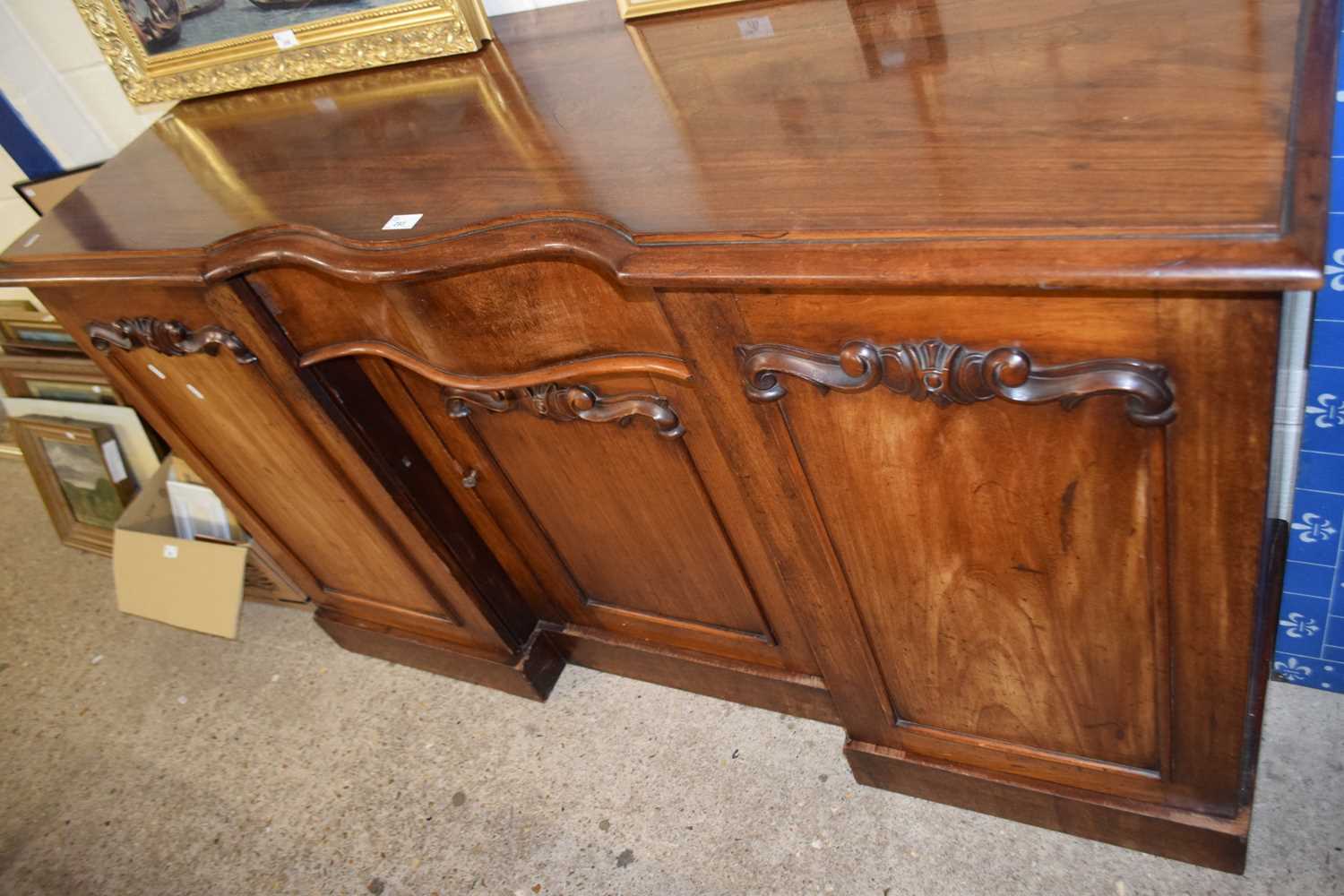 A mahogany break front side board with cupboards to either side, centered serpentine fronted