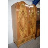 20th Century two door walnut veneered wardrobe with arched doors over a single drawer base, 118cm