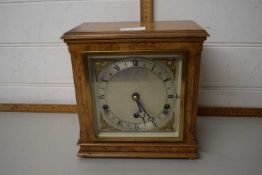 A maple veneered wall clock with chrome and brass finish dial